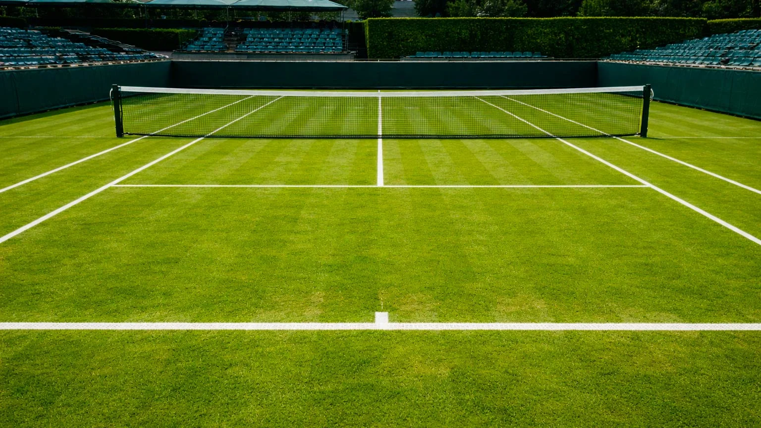 Gepflegter Rasen-Tennisplatz mit weißen Linien und Netz bei Wimbledon-Atmosphäre