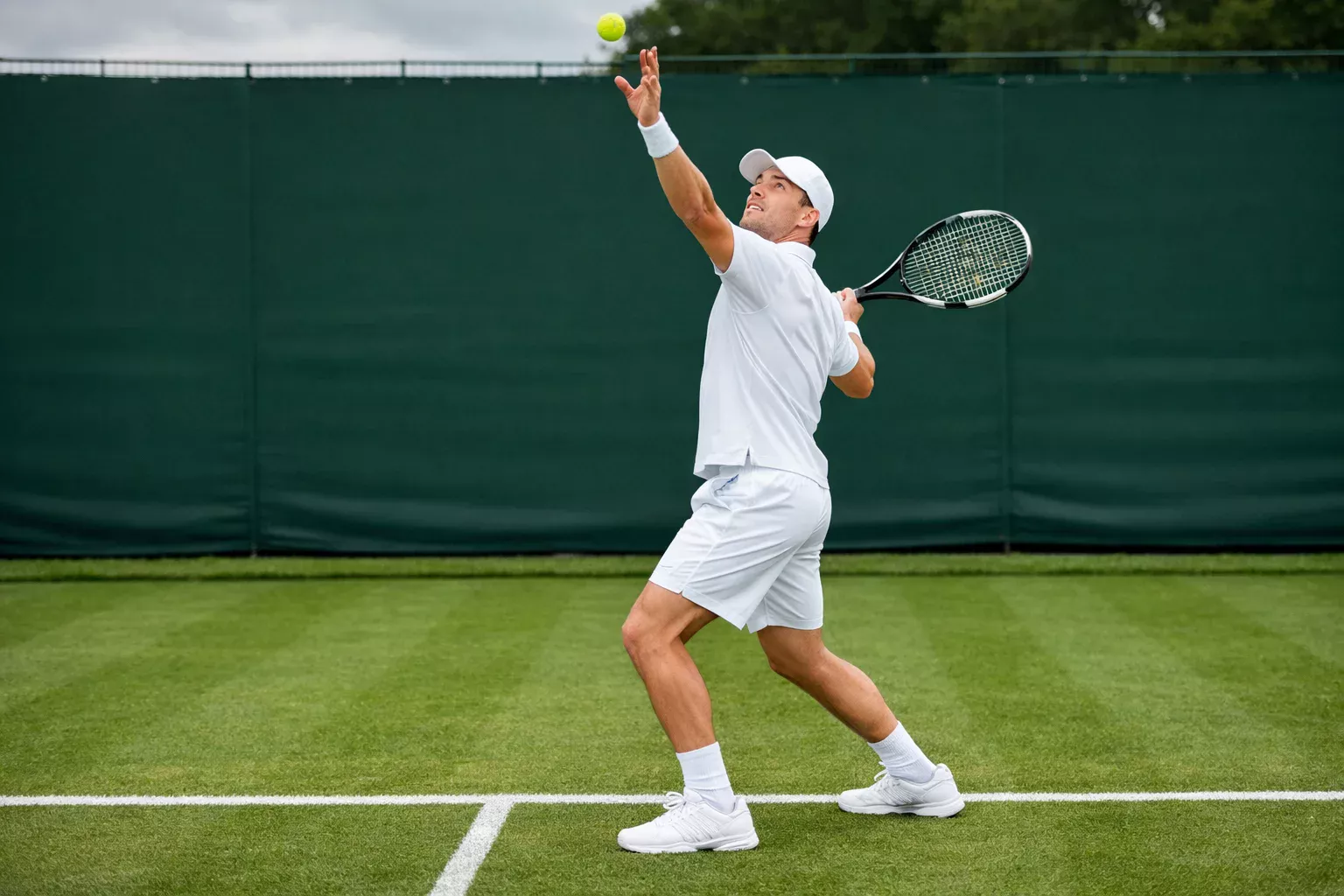 Klassischer Rasenplatz mit Tennisspieler in weißer Kleidung